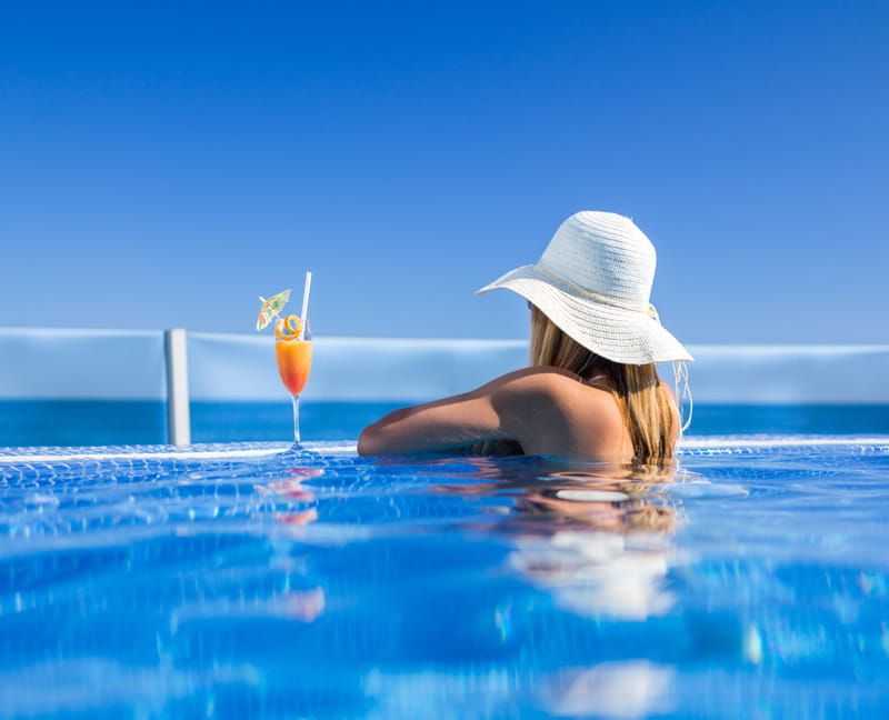 Single woman relaxing in an infinity pool on holiday
