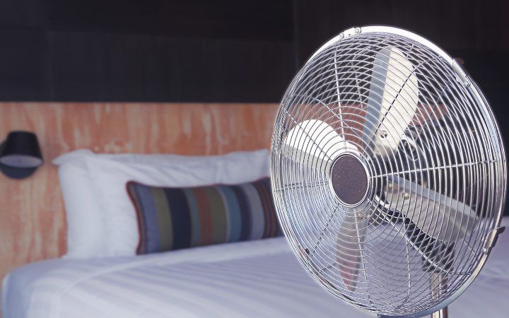 A fan blowing cool air in a hot hotel room.