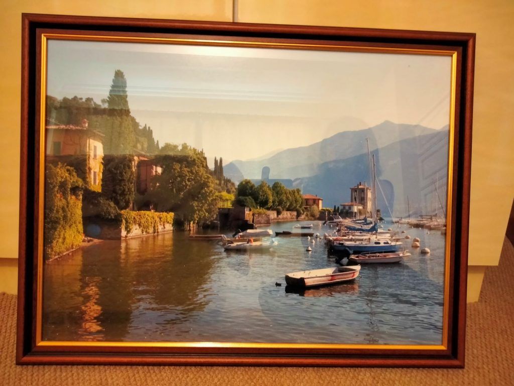 A beautiful framed painting of boats on Lake Como.