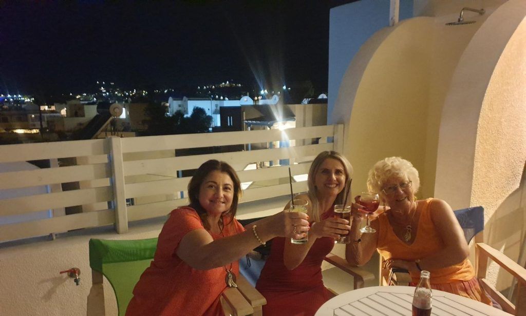 Three people cheers at hotel in Greece.